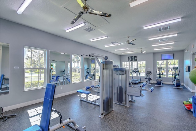 exercise room featuring a wealth of natural light, visible vents, and a textured ceiling