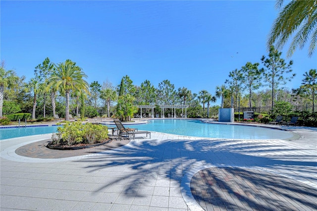 community pool with a patio, fence, and a pergola