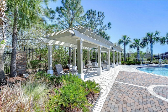 pool with a patio area, a pergola, and fence