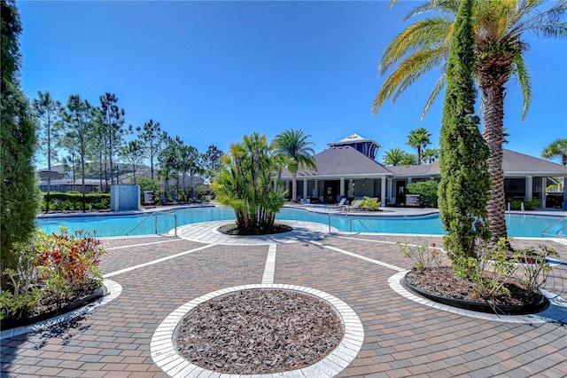 community pool with a patio and fence