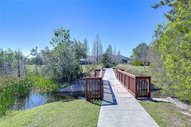 view of community with a lawn and a water view