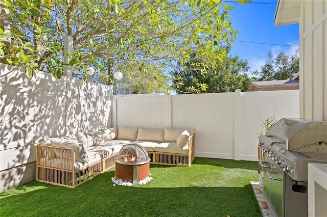 view of yard featuring a fenced backyard and an outdoor living space with a fire pit