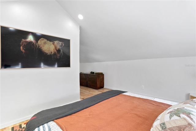 bedroom with lofted ceiling, recessed lighting, wood finished floors, and baseboards