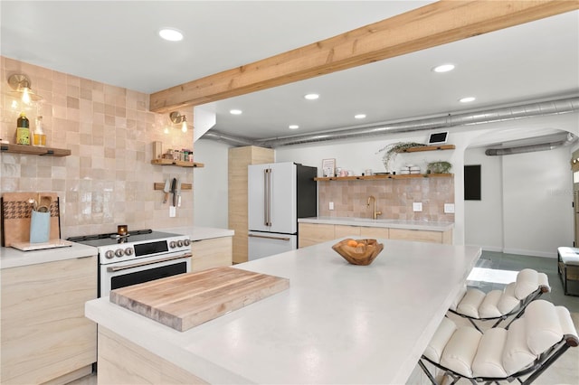 kitchen featuring high end white refrigerator, electric range, open shelves, and a sink