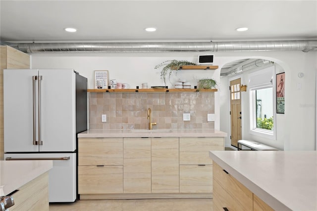 kitchen with modern cabinets, light brown cabinets, light countertops, and freestanding refrigerator