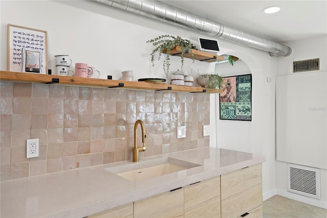 interior space with tasteful backsplash, visible vents, a sink, and open shelves