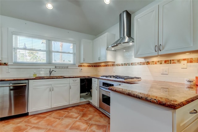 kitchen with light tile patterned flooring, a sink, appliances with stainless steel finishes, wall chimney range hood, and backsplash
