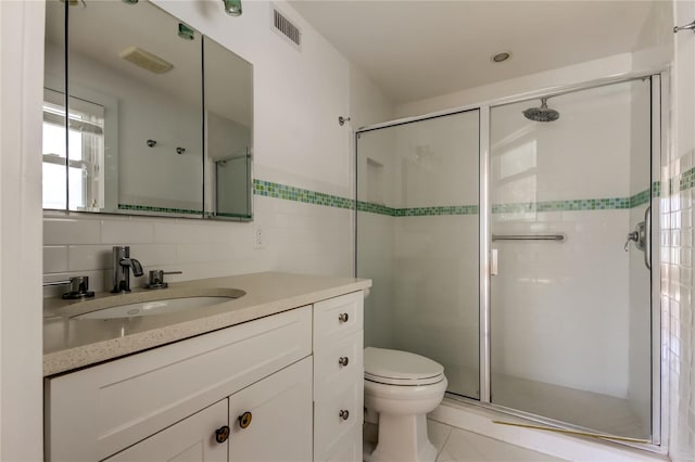 bathroom with visible vents, toilet, a stall shower, tile walls, and vanity