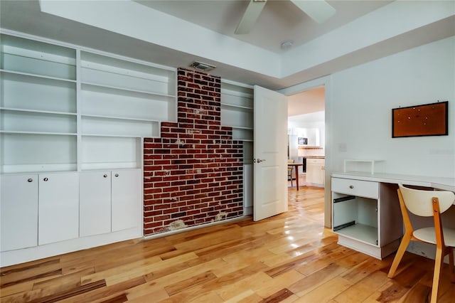 office space featuring visible vents, brick wall, light wood-type flooring, and ceiling fan