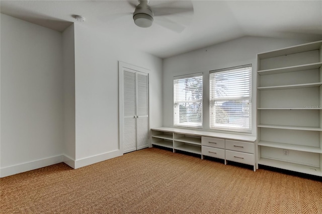 unfurnished bedroom with baseboards, lofted ceiling, light carpet, a closet, and a ceiling fan