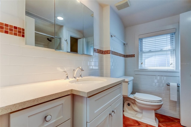 full bath with tile patterned floors, visible vents, toilet, tile walls, and walk in shower