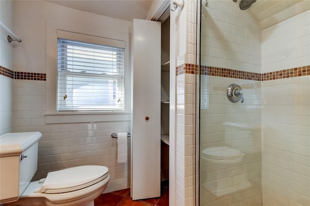 bathroom featuring a shower stall, toilet, and tile walls