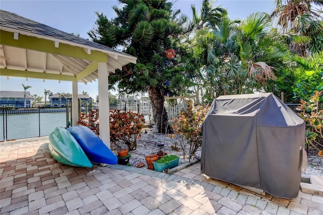 view of patio / terrace with a gazebo, area for grilling, a water view, and fence