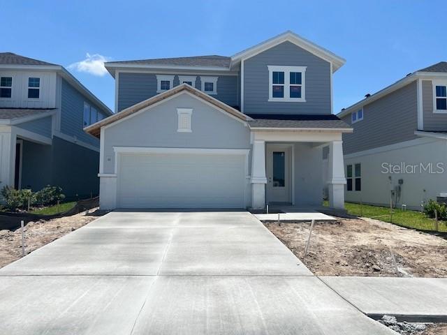 28740 Jujube Rd, Wesley Chapel, FL 33543 - traditional-style home featuring driveway, an attached garage, and covered porch