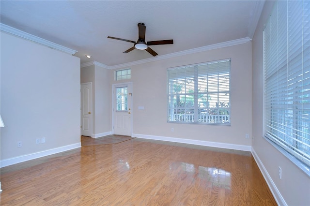 spare room featuring baseboards, ceiling fan, wood finished floors, and crown molding