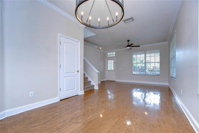 unfurnished living room featuring visible vents, stairway, ornamental molding, wood finished floors, and baseboards