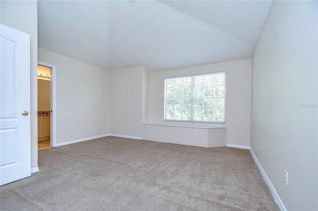 unfurnished room featuring lofted ceiling, carpet, and baseboards