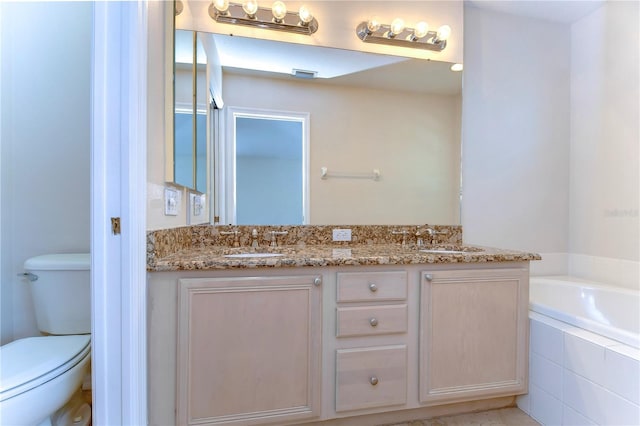 full bathroom featuring toilet, a garden tub, double vanity, and a sink