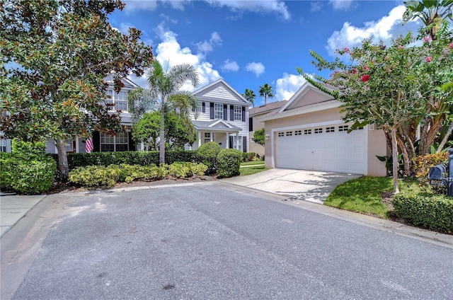 view of front of home with concrete driveway, an attached garage, and stucco siding