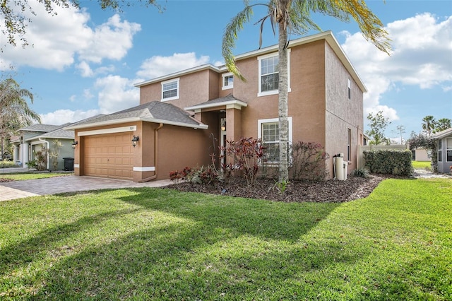 traditional-style home with decorative driveway, a front lawn, and stucco siding