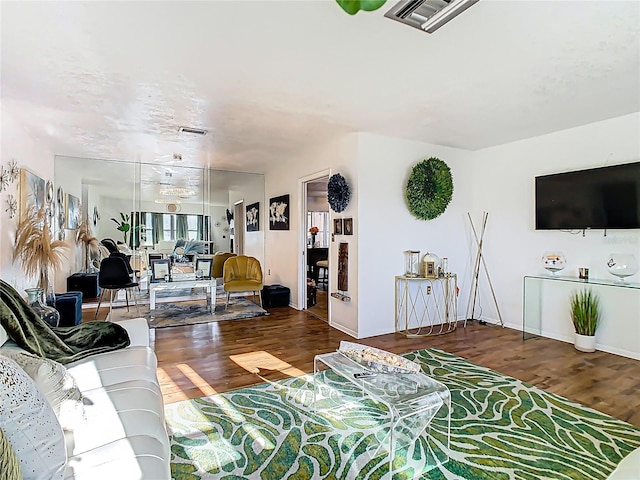 living area with visible vents and wood finished floors