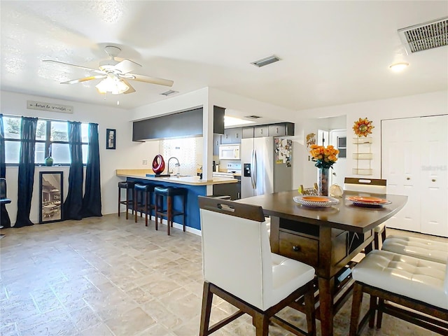 dining area featuring visible vents, stone finish floor, and ceiling fan