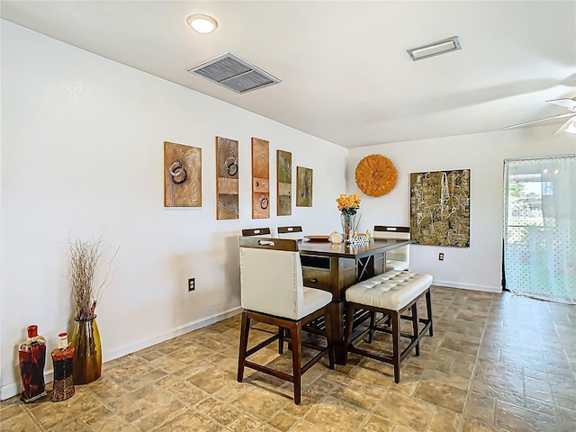 dining room with visible vents, baseboards, and stone finish flooring