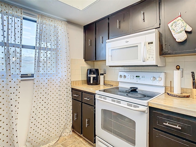 kitchen featuring white appliances, backsplash, and butcher block counters