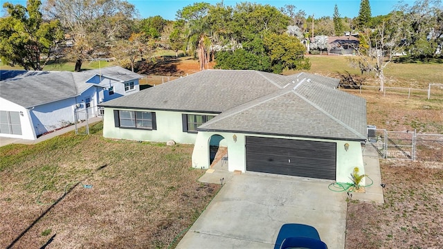 view of front of property with a front lawn, fence, concrete driveway, stucco siding, and an attached garage