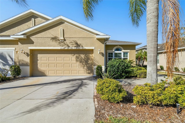 view of front of house with stucco siding, driveway, and a garage