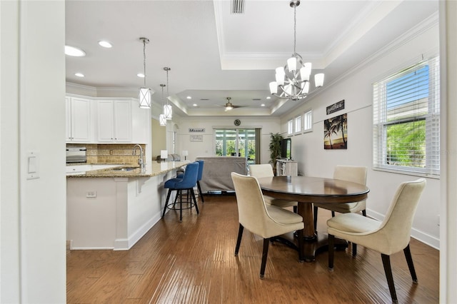 dining room with visible vents, baseboards, ornamental molding, dark wood-style floors, and a raised ceiling