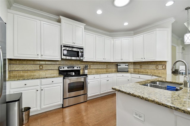 kitchen with a sink, stainless steel appliances, backsplash, and white cabinets