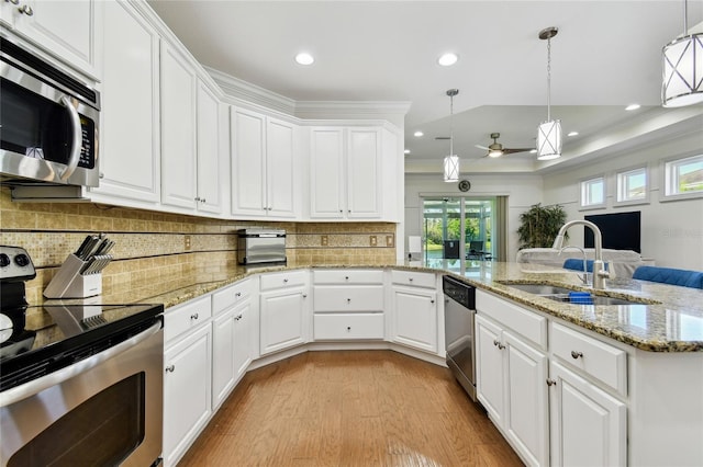 kitchen with ornamental molding, a sink, white cabinets, light wood-style floors, and appliances with stainless steel finishes