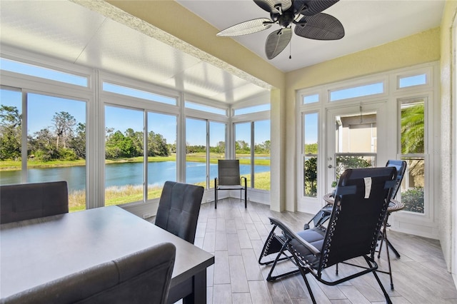 sunroom / solarium featuring a ceiling fan and a water view