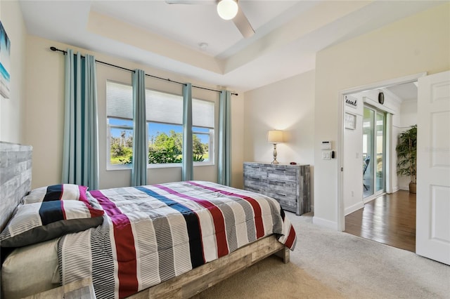 bedroom with a tray ceiling, baseboards, carpet, and ceiling fan