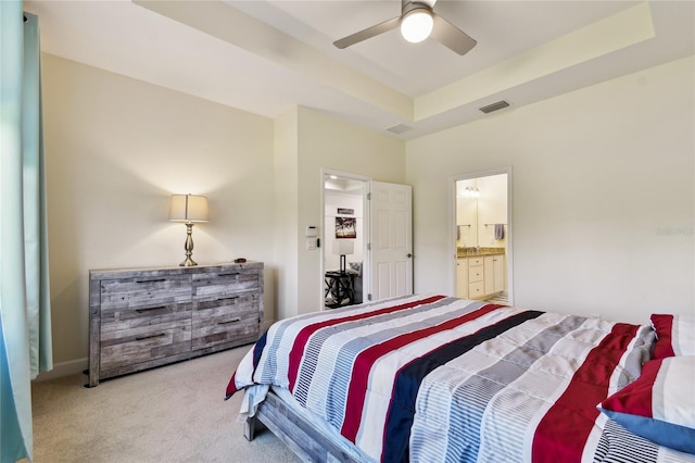 bedroom featuring a tray ceiling, carpet flooring, visible vents, and ceiling fan