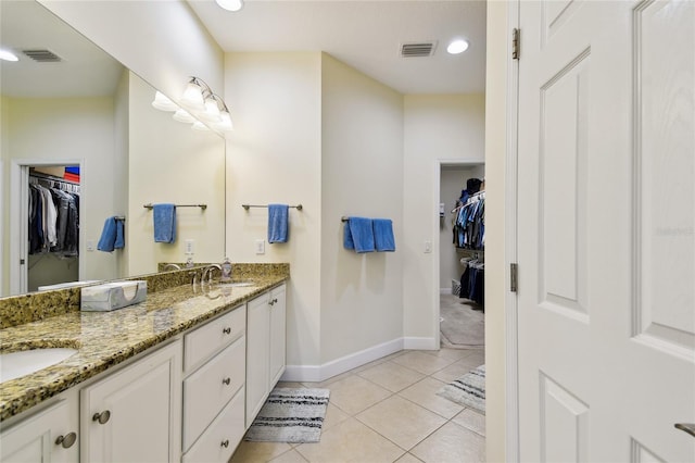 full bath with tile patterned flooring, double vanity, visible vents, and a sink