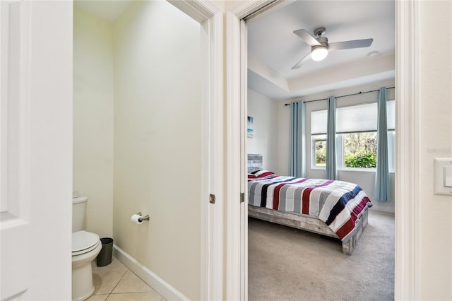 carpeted bedroom featuring baseboards, ceiling fan, and tile patterned flooring