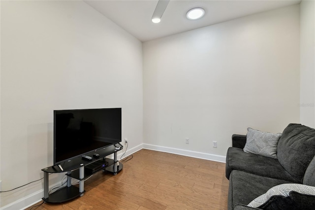 living area with ceiling fan, baseboards, and wood finished floors