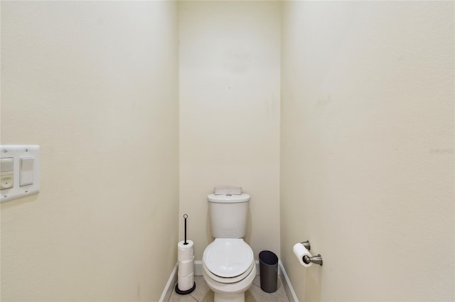 bathroom with tile patterned floors, baseboards, and toilet