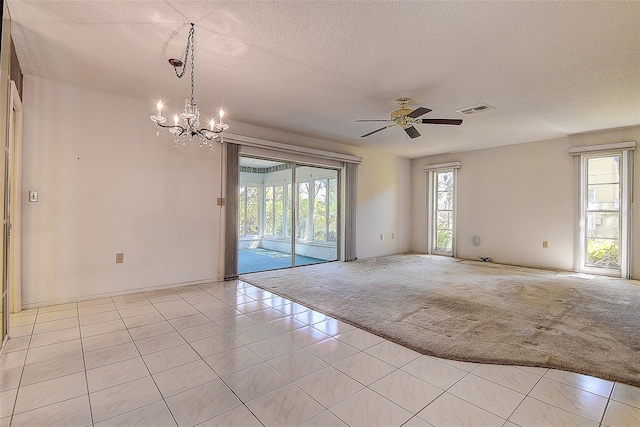 unfurnished room featuring light tile patterned floors, visible vents, a textured ceiling, ceiling fan with notable chandelier, and light colored carpet