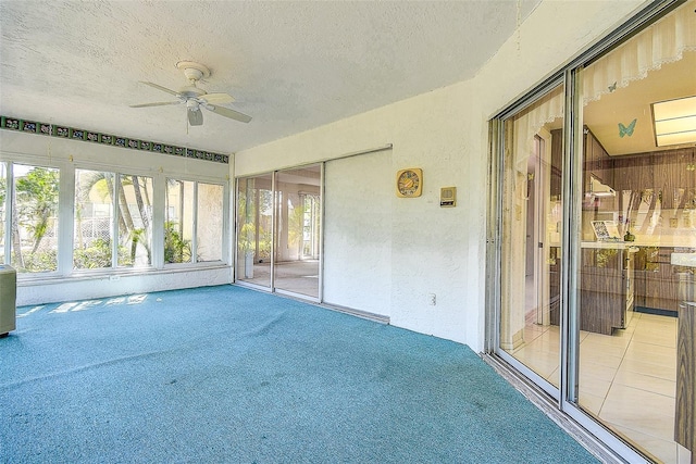 unfurnished sunroom featuring a ceiling fan