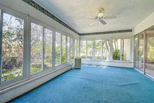 unfurnished sunroom with ceiling fan