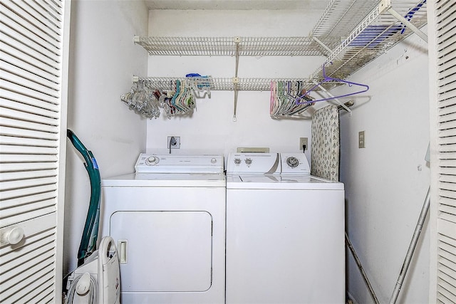 clothes washing area featuring separate washer and dryer and laundry area