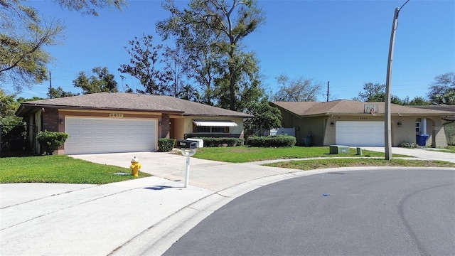 ranch-style house featuring a garage, driveway, a front yard, and stucco siding