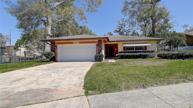 ranch-style home with fence, an attached garage, stucco siding, a front lawn, and concrete driveway