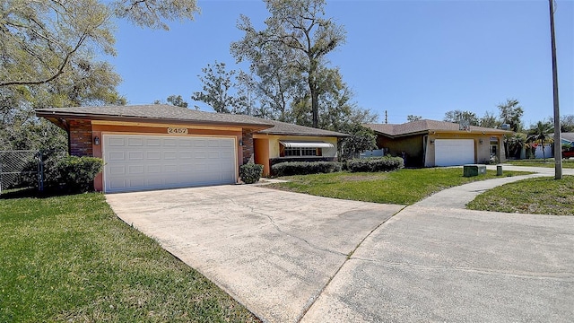 ranch-style home featuring driveway, a front yard, an attached garage, and fence