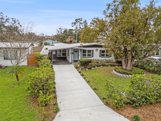 view of front of property with driveway, stucco siding, a carport, and a front yard