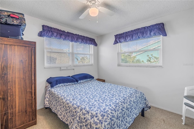 carpeted bedroom with ceiling fan, baseboards, and a textured ceiling