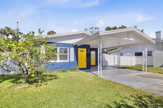 view of front of house featuring driveway, a front lawn, fence, and an attached carport